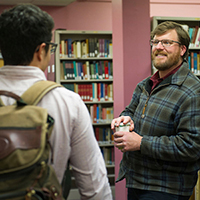 "staff member talking with a student"