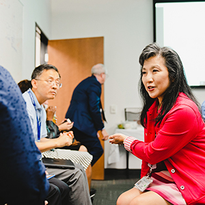 "woman talking with people in an office space"