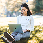 "young woman using a laptop outdoors"