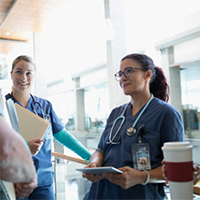 "group of nurses talking with one another"