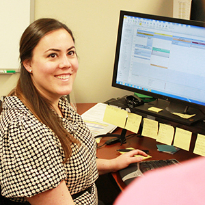 "employee of uc davis looking up from her computer to talk to a colleague"