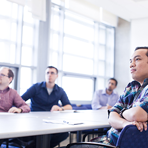 "group of men listening during a meeting"