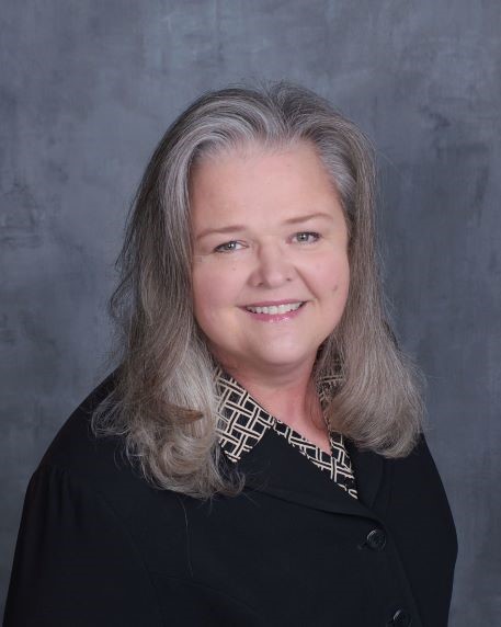 Photo of Michele Haynes in a black shirt and smiling.