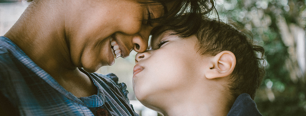 mother smiling and touching her forehead to her young son's