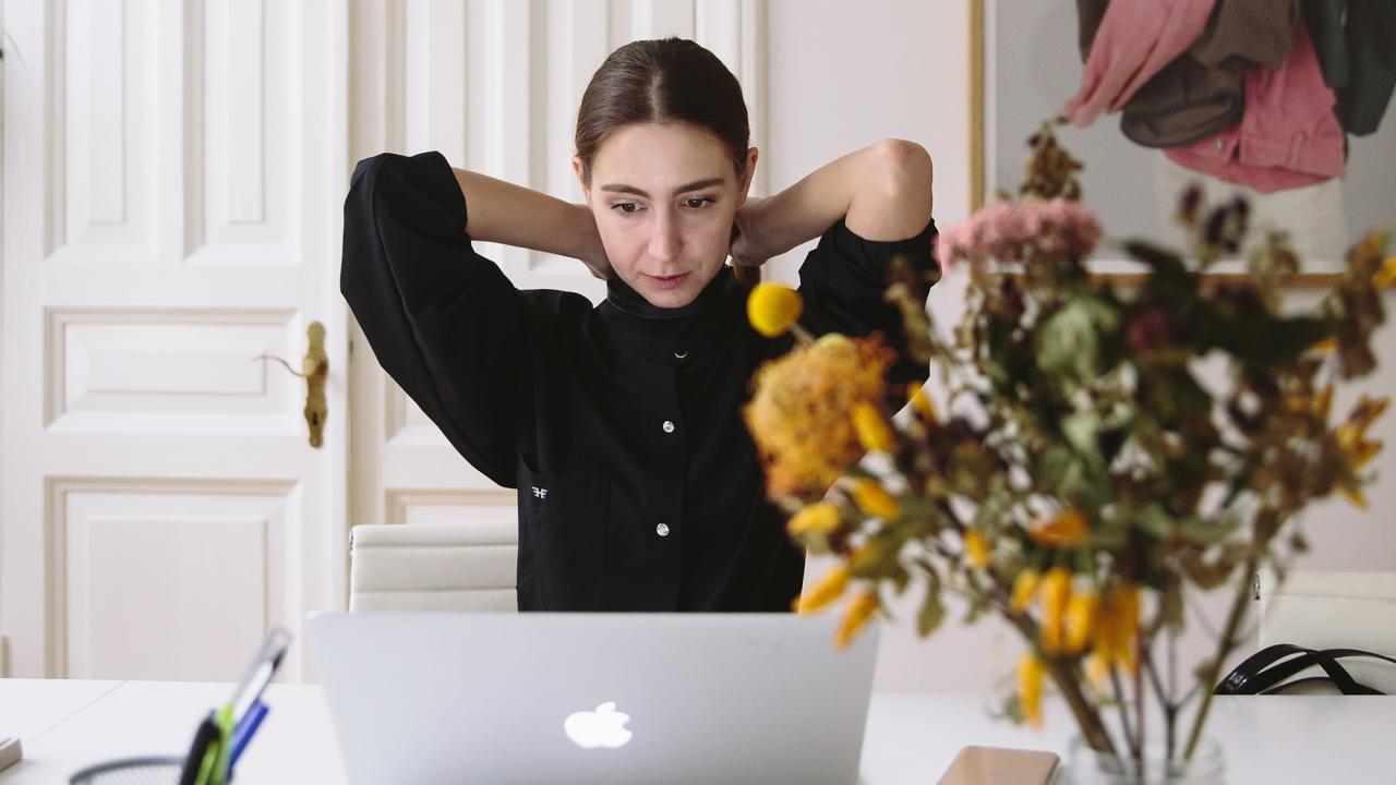 woman working at a kitchen table on laptop