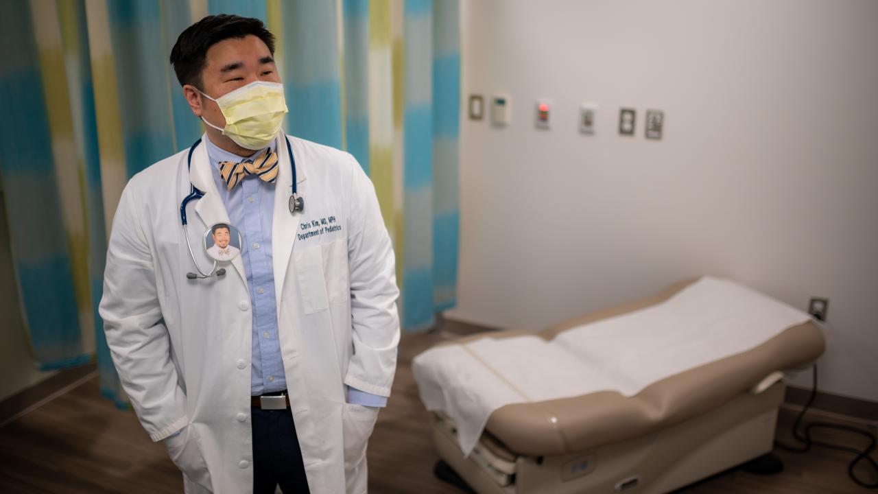 Doctor standing in examination room alone and reflecting.