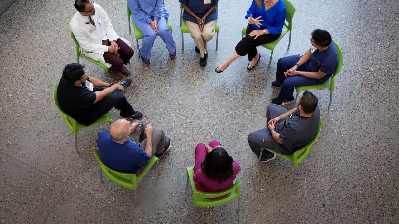 A group of people sitting in a circle, appearing to be in a support group.
