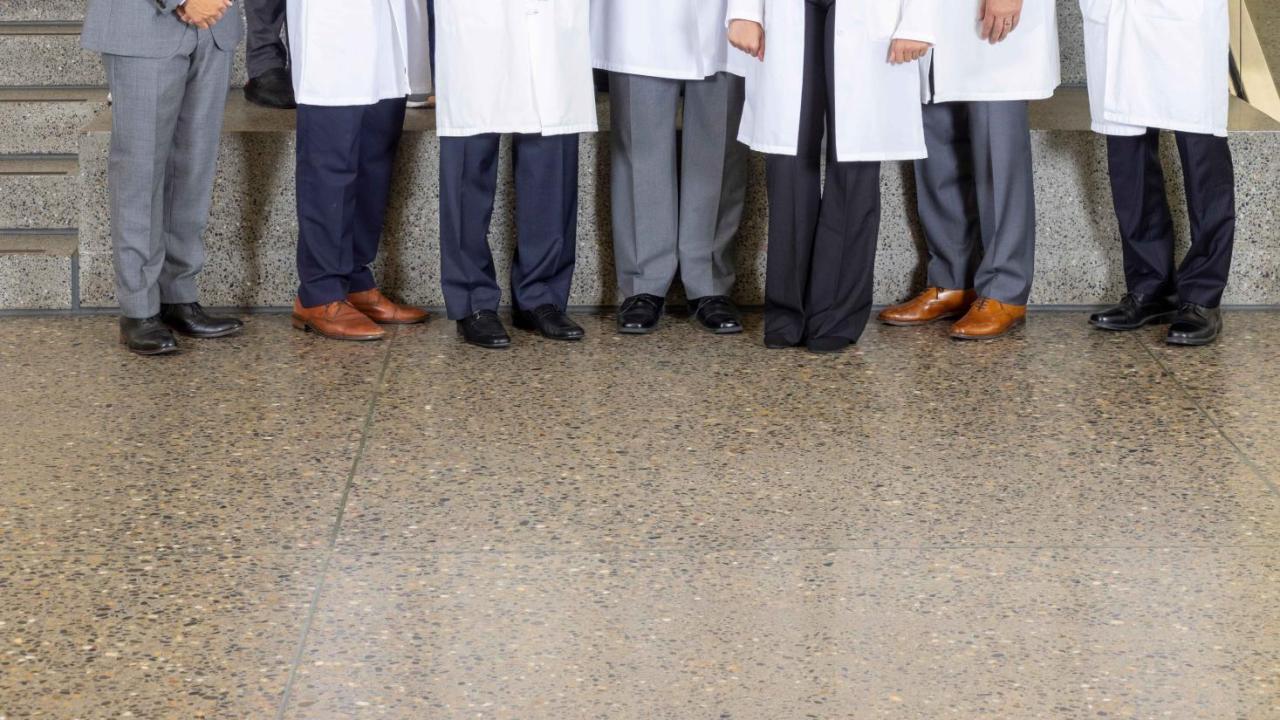 Group of doctors and nurses standing together on some steps.  