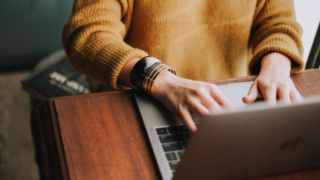 Person typing on a laptop computer.