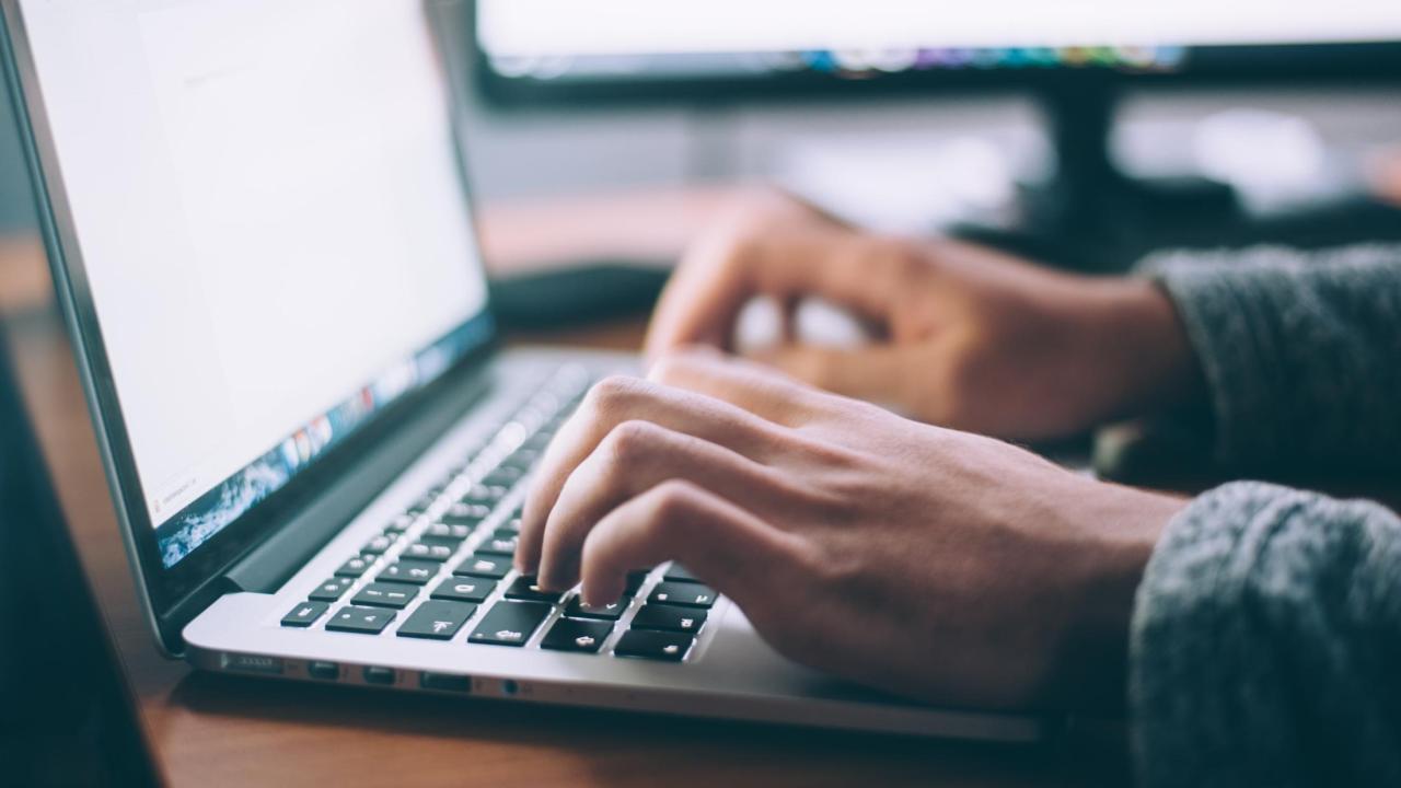 Person typing on a laptop computer.