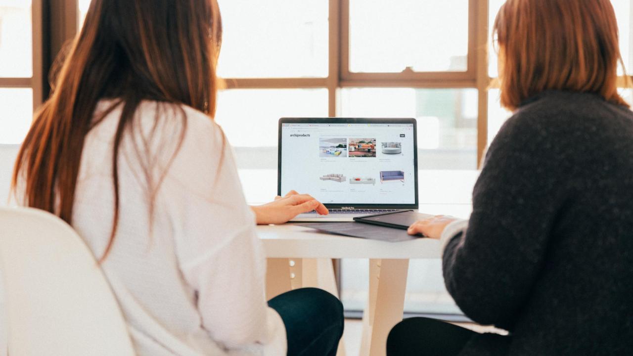 People looking at a laptop computer.