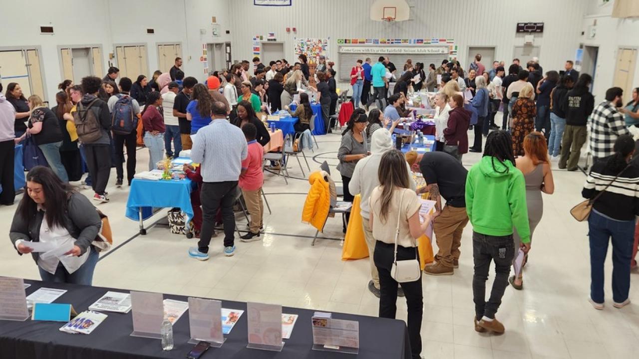 Overhead view of busy indoor expo hall with many people at tables and booths5