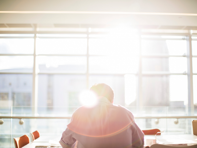 man at his computer with a ray of sun over his shoulder