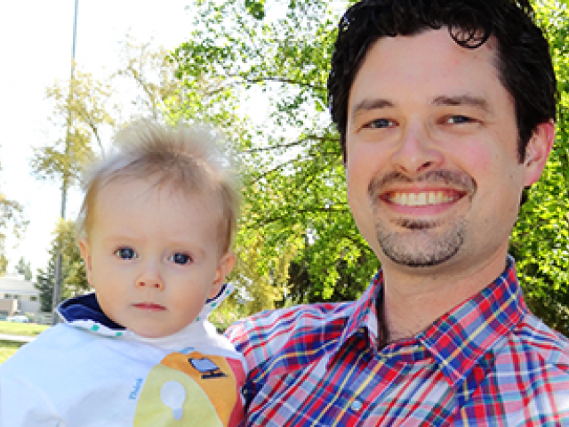 smiling father holding is young child