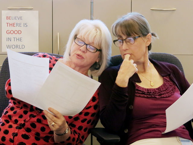 two female collagues looking at forms with one another