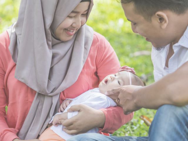 young parents smiling at their baby