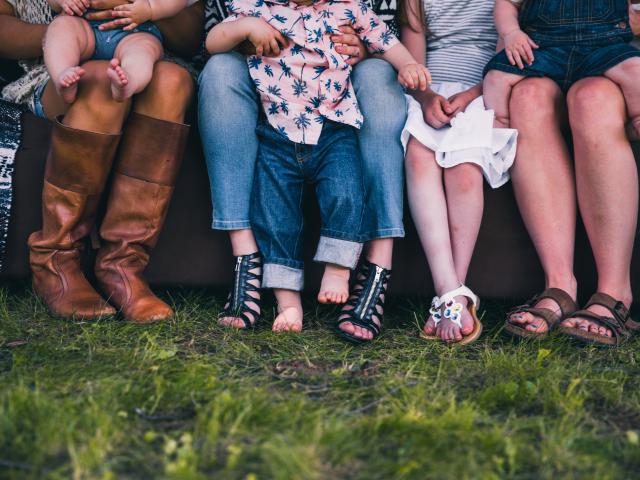 Shot of legs showing a group of mothers and children in a row