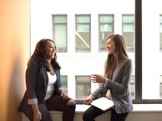 daytime employees talking by window