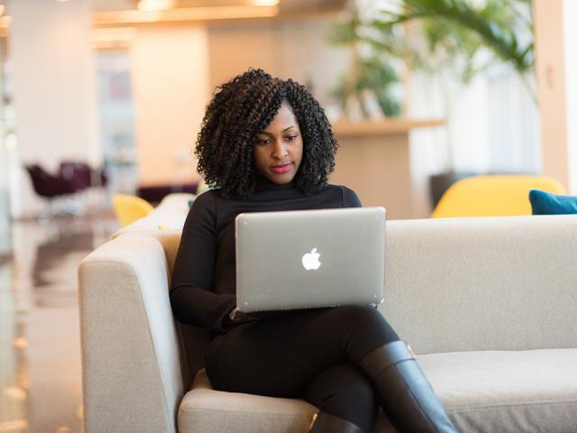 woman sitting calmly and looking at laptop