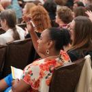 People sitting at a presentation with their hands raised. 