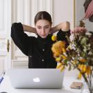 woman working at a kitchen table on laptop