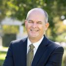 Jim Hankins Headshot. He is wearing a blue suit and smiling at the camera.