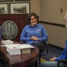 Man and woman sitting around office table.