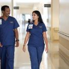 Two registered nurses walking side by side down the hallway