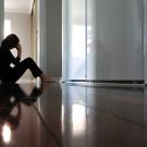 Woman is sitting on the floor alone.  