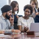 Diverse group of employees sit around a table.
