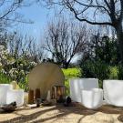 Outdoor sound-healing setup with white crystal bowls and a brass gong