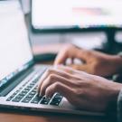 Person typing on a laptop computer.