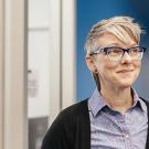 Smilling woman wearing glasses.