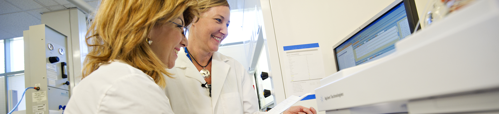 two female researchers looking at data on a computer screen