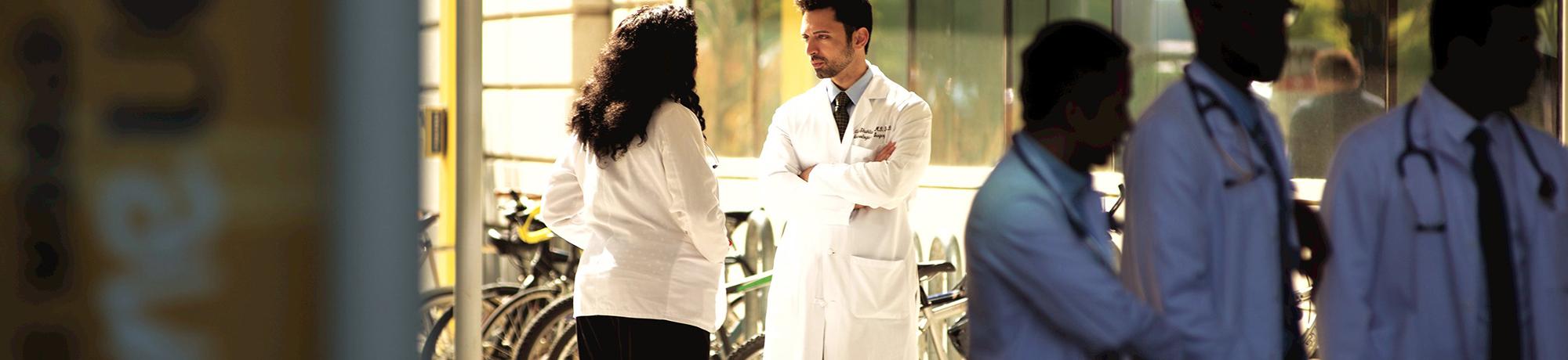 doctor standing outside the uc davis medical center speaking with another doctor