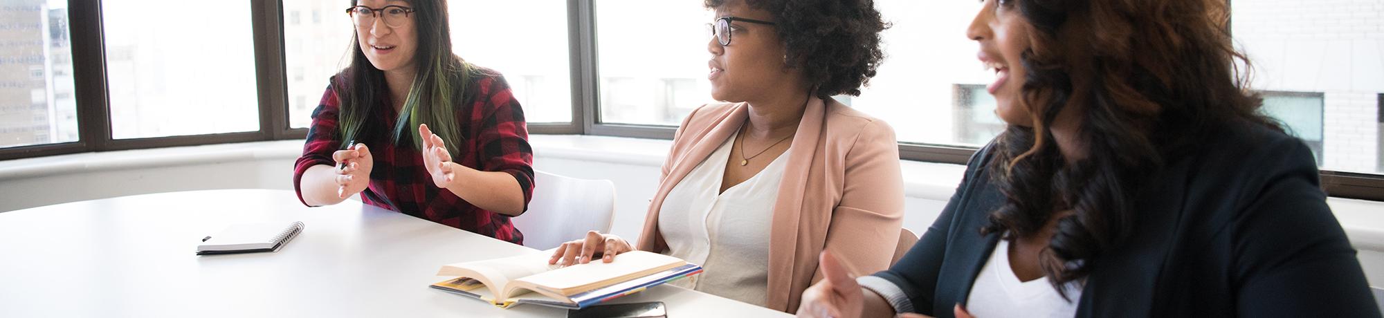 three colleagues talking around a conference table