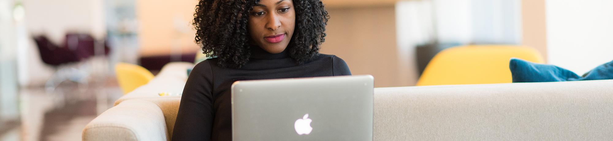 woman smiling and working on a laptop