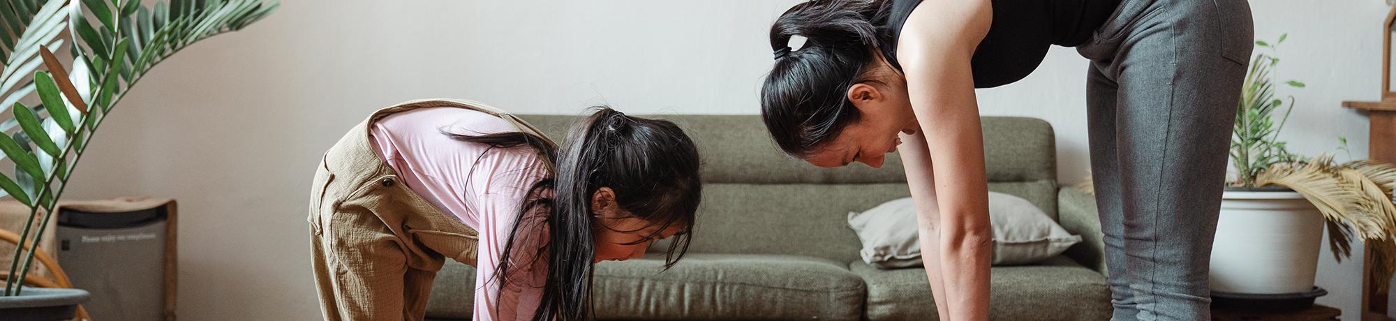 woman and her daughter stretching together